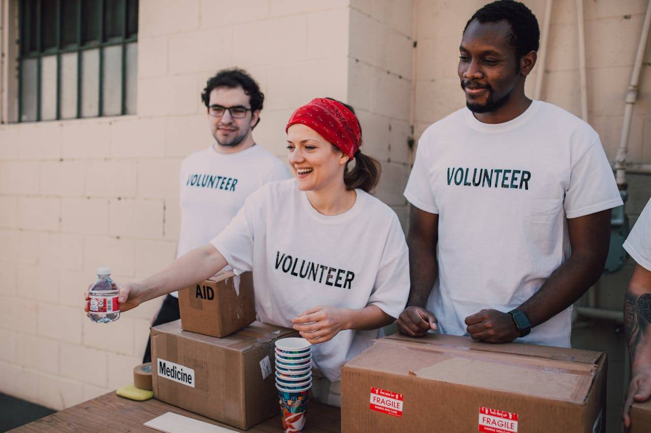 3 volunteers handing out food.