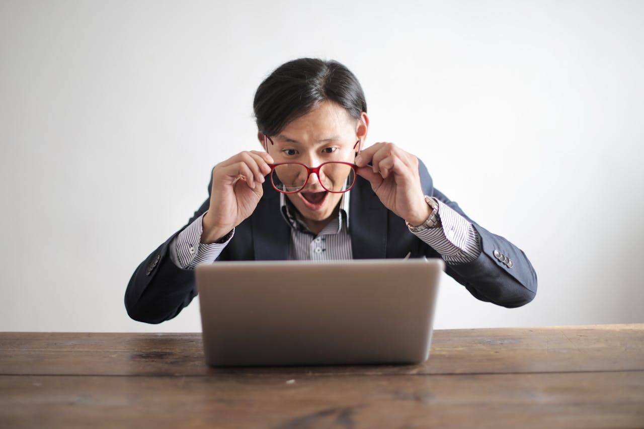 A man reading facts on a laptop with amazement