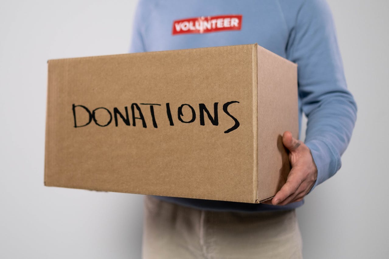 a person holds a cardboard donation box