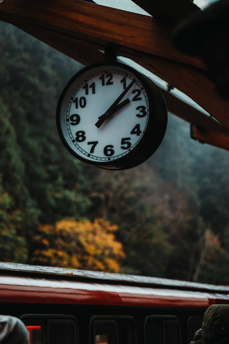 A clock hangs over a train station.