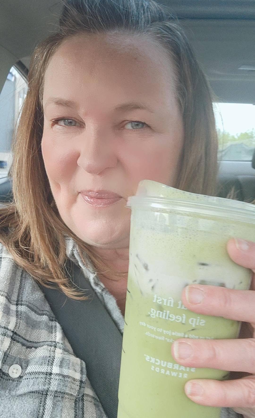 woman holding iced lavender cream oat milk matcha from Starbucks