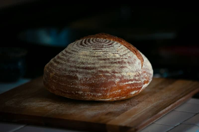 A rustic loaf of sourdough bread on a wooden board