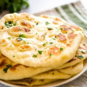 stack of Naan bread topped with fresh parsley