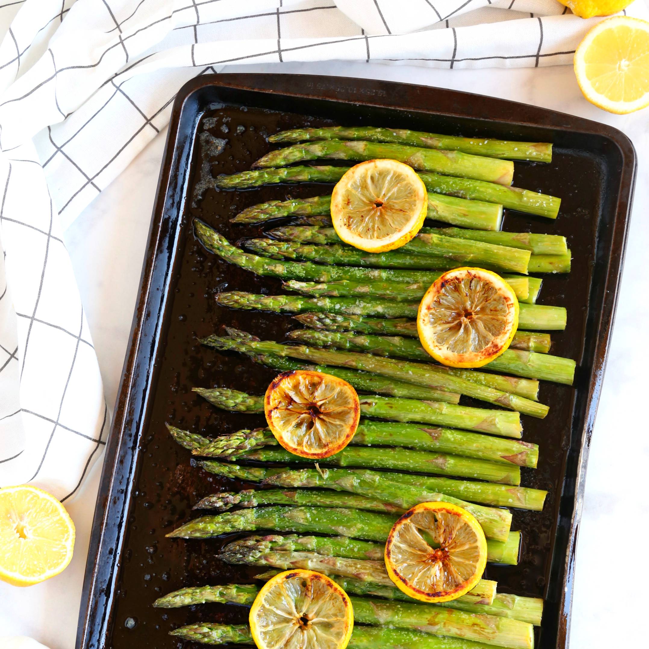 sheet pan of asparagus with lemon slices on top