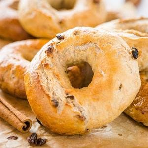 a cinnamon raisin bagel propped in front of other cinnamon raisin bagels