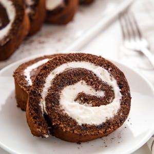 two slices of Chocolate Swiss Roll with whipped cream filling on a plate