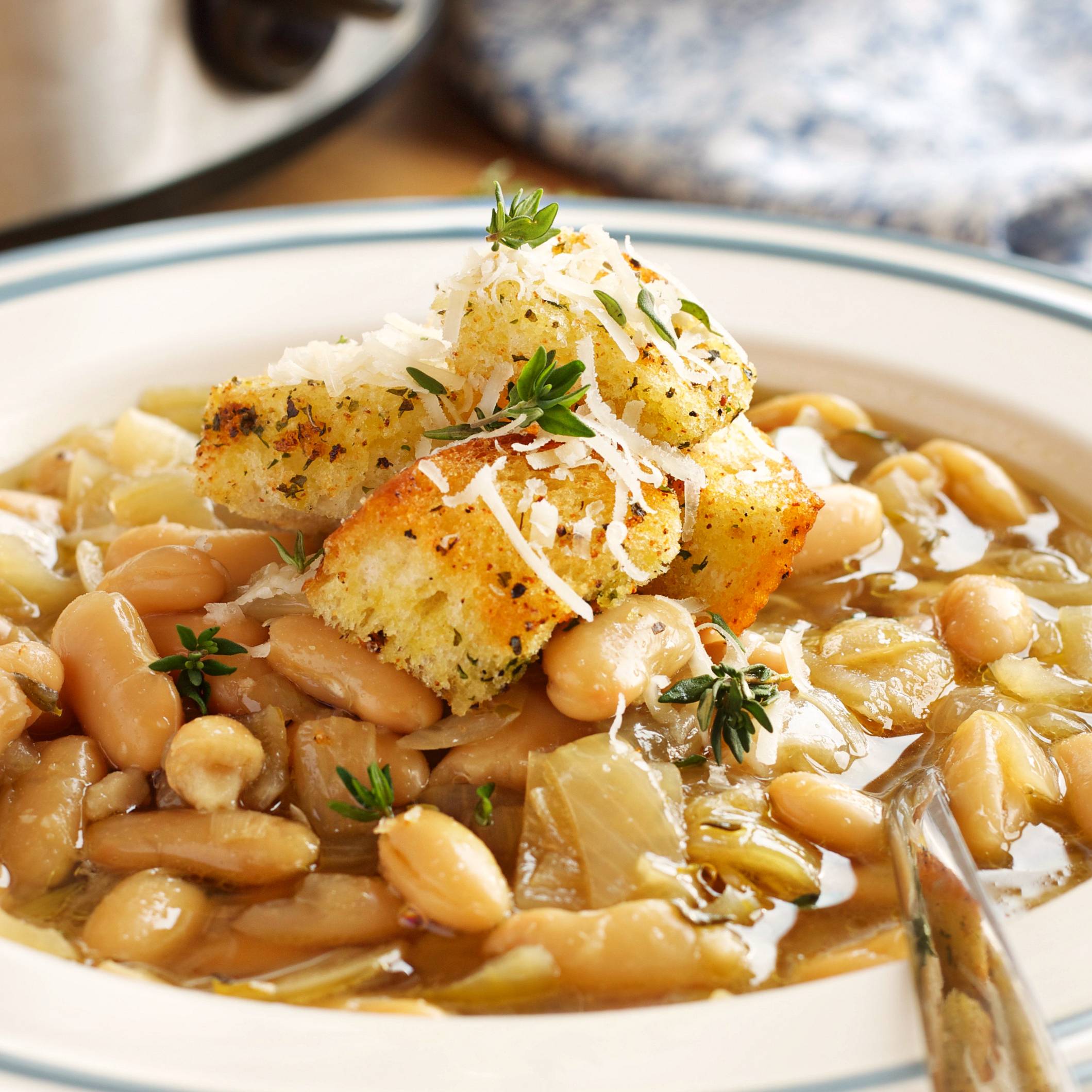 bowl of French Onion Bean soup topped with croutons and herbs
