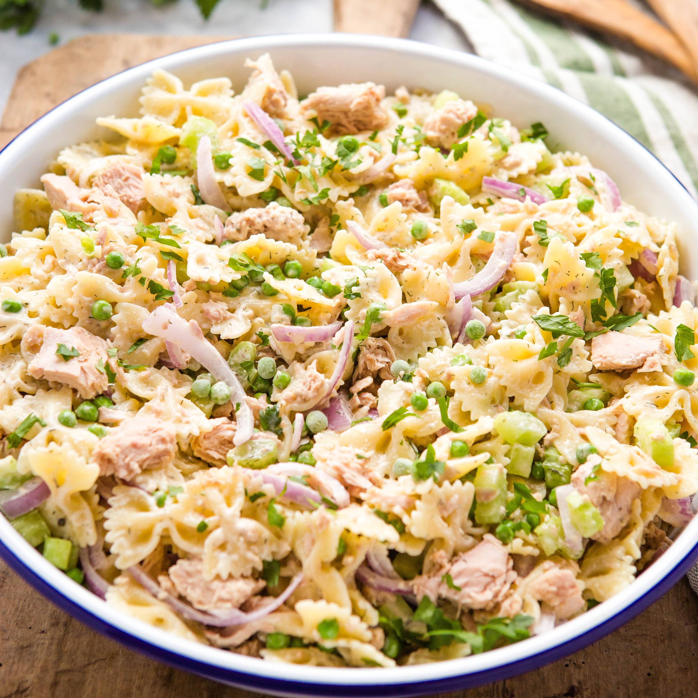 bowl of tuna pasta salad topped with fresh herbs