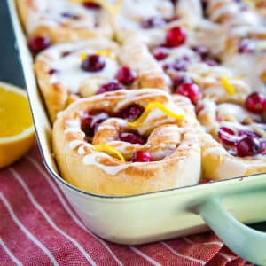 baking dish of Cranberry Orange Sweet Rolls drizzled with glaze