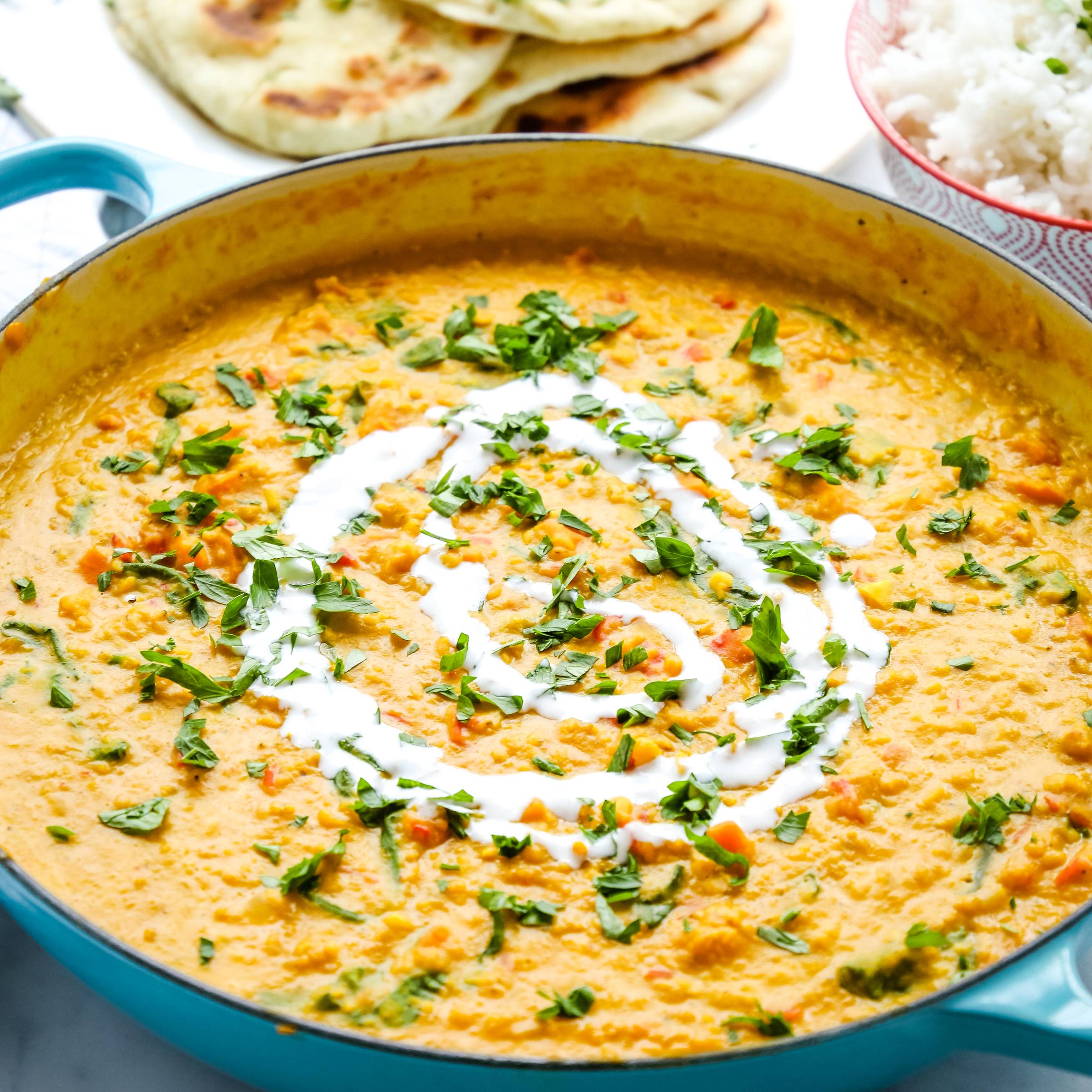 pot of lentil daal curry topped with fresh herbs