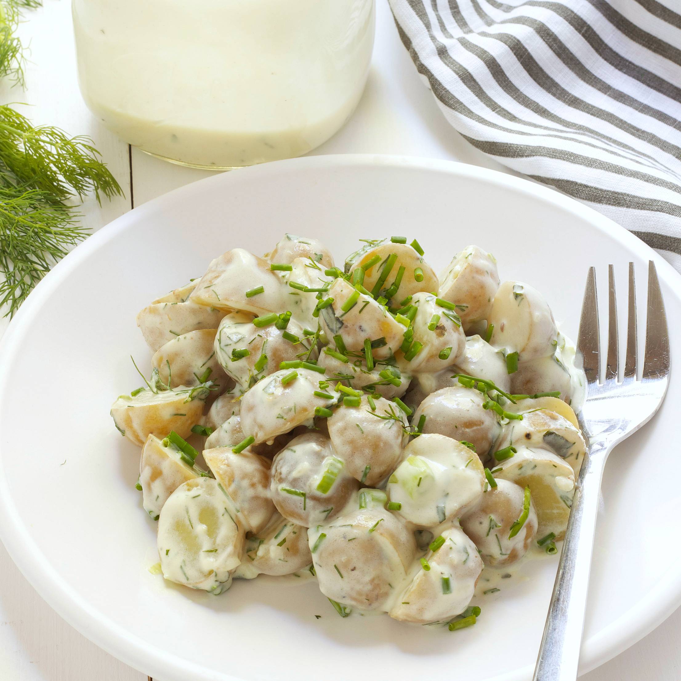 healthy buttermilk ranch potato salad topped with fresh herbs