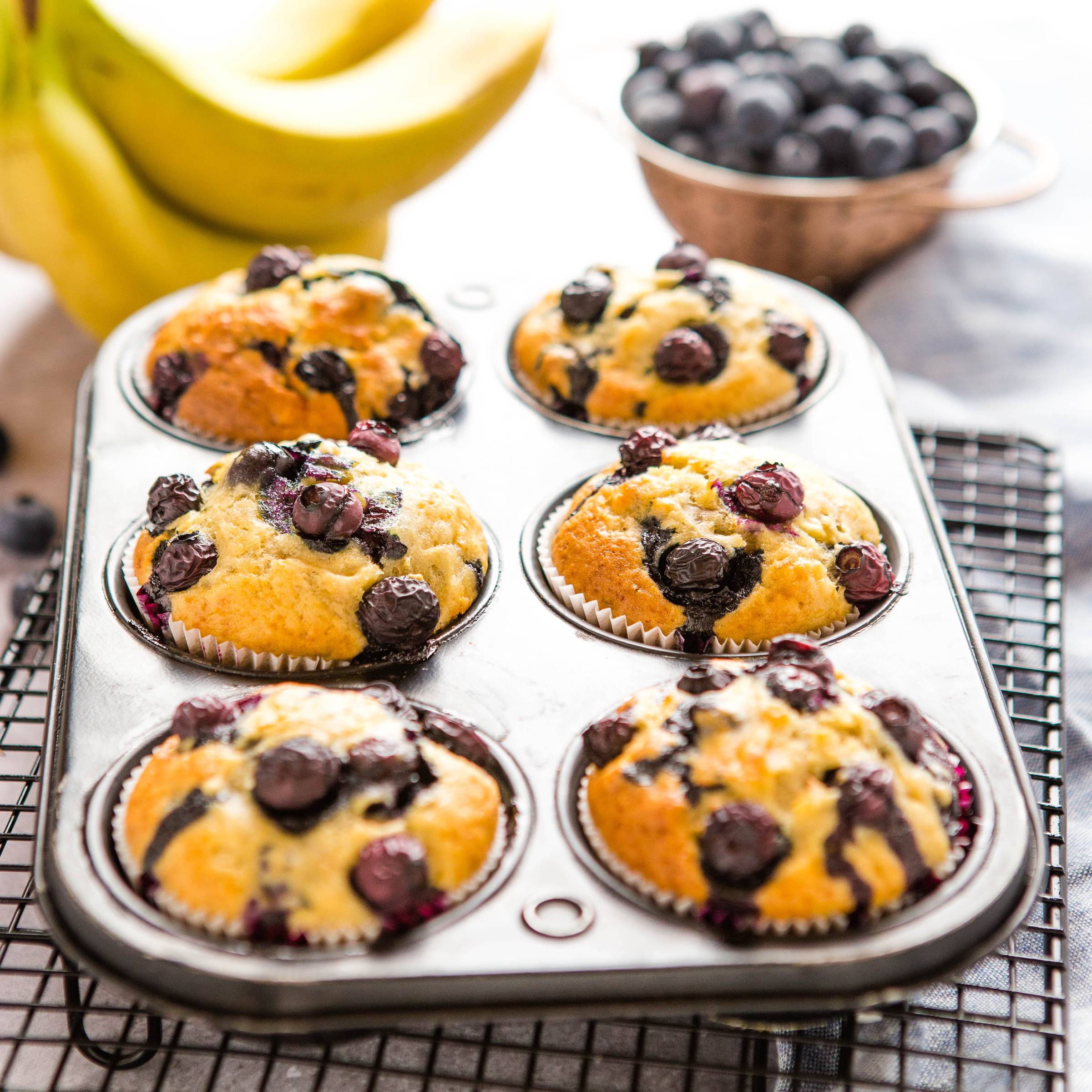 a muffin tin with Banana Blueberry Muffins