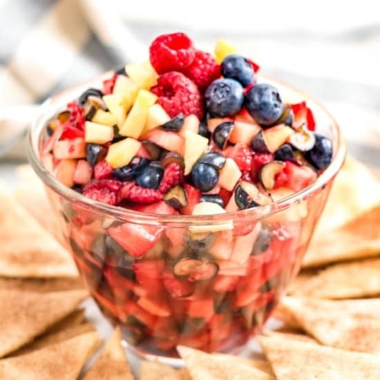 bowl of fresh berries and apples cut into small pieces.