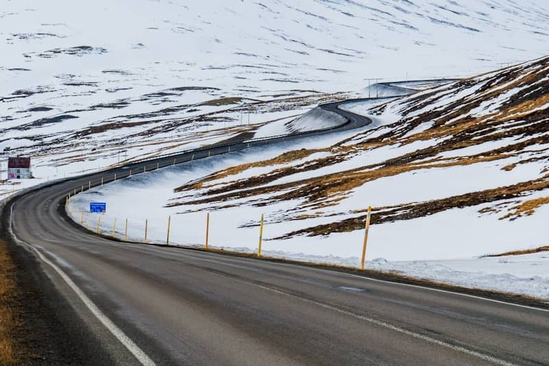 Winding road through snowy, barren landscape
