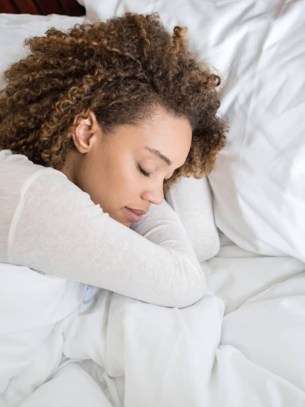 A mom laying in her bed sleeping.