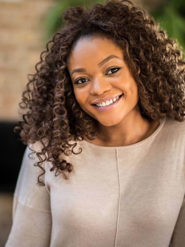 African American woman smiling at the camera.