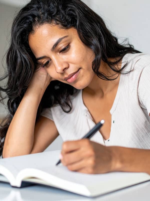 A mom sitting at the table writing in her journal.