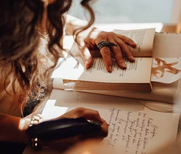 A mother with an open book and writing in a journal.