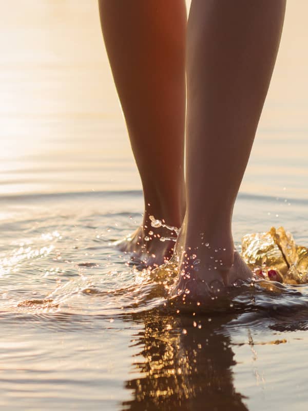 Picture of a Woman's legs and feet walking in the water