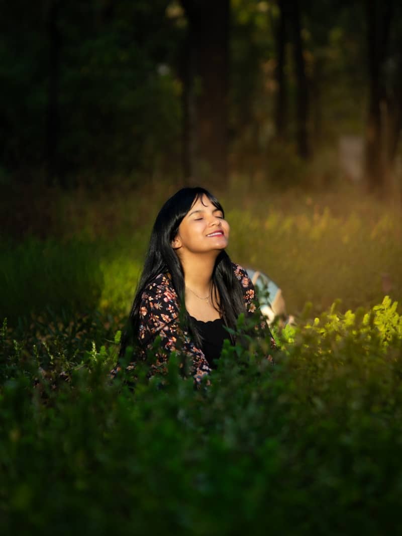 Young woman smiling in lush green foliage