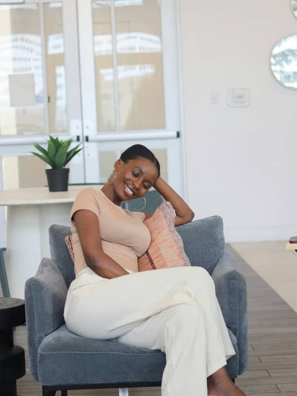 African American woman sitting in a chair smiling and relaxing.
