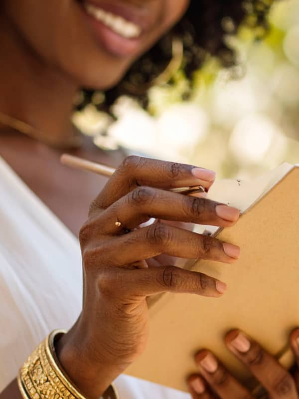 A mother smiling writing in her journal.