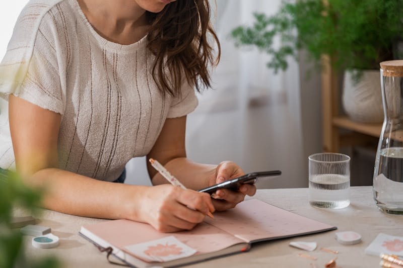 a woman writing on a piece of paper