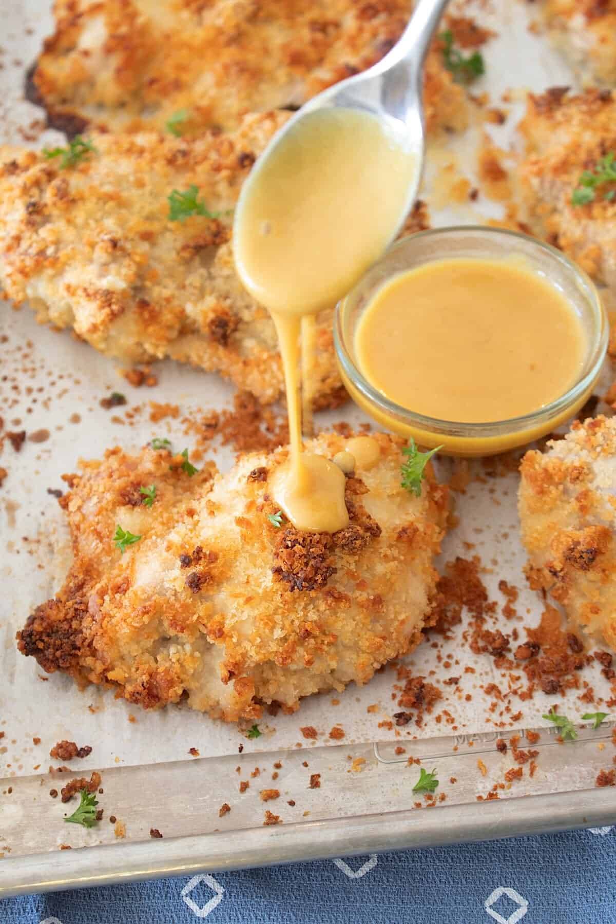 crunchy chicken on a sheet pan with honey mustard drizzle