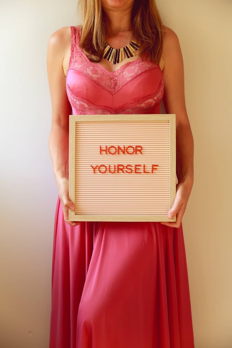 Woman holding a sign that says "honor yourself".