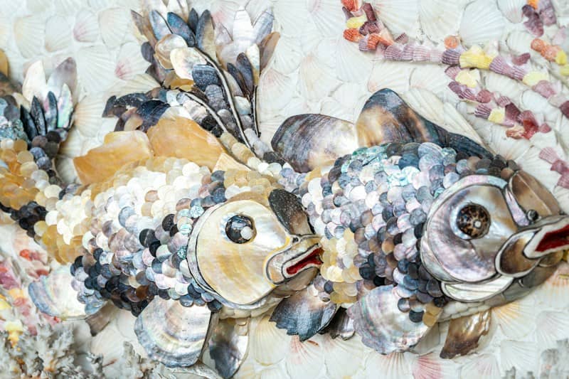 Two ornate fish made of shells and mosaic