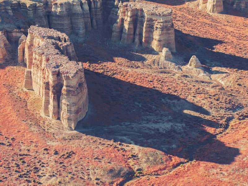 Tall rock formations casting long shadows in desert landscape