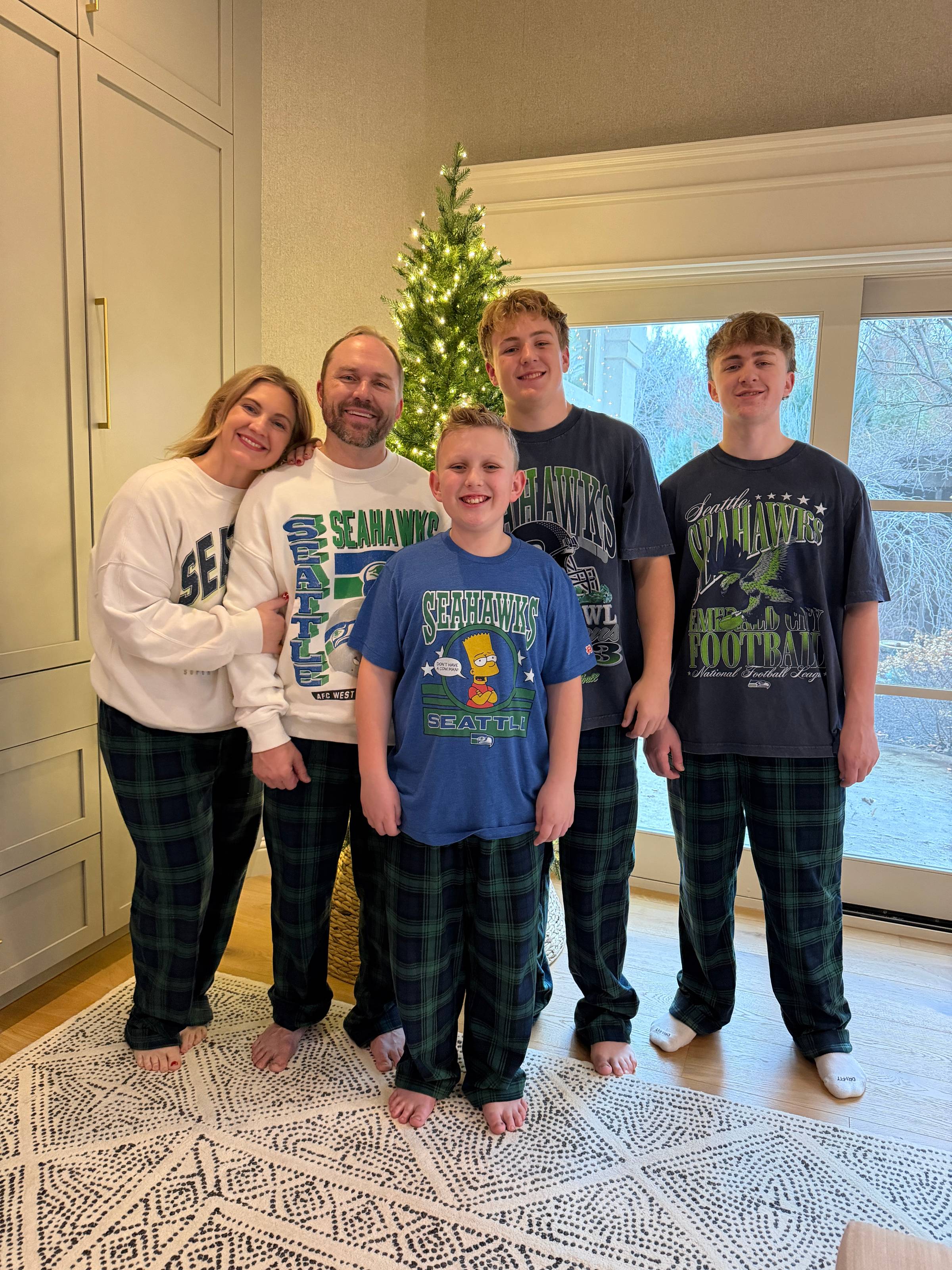 A family in seahawks shirts poses together for a photo