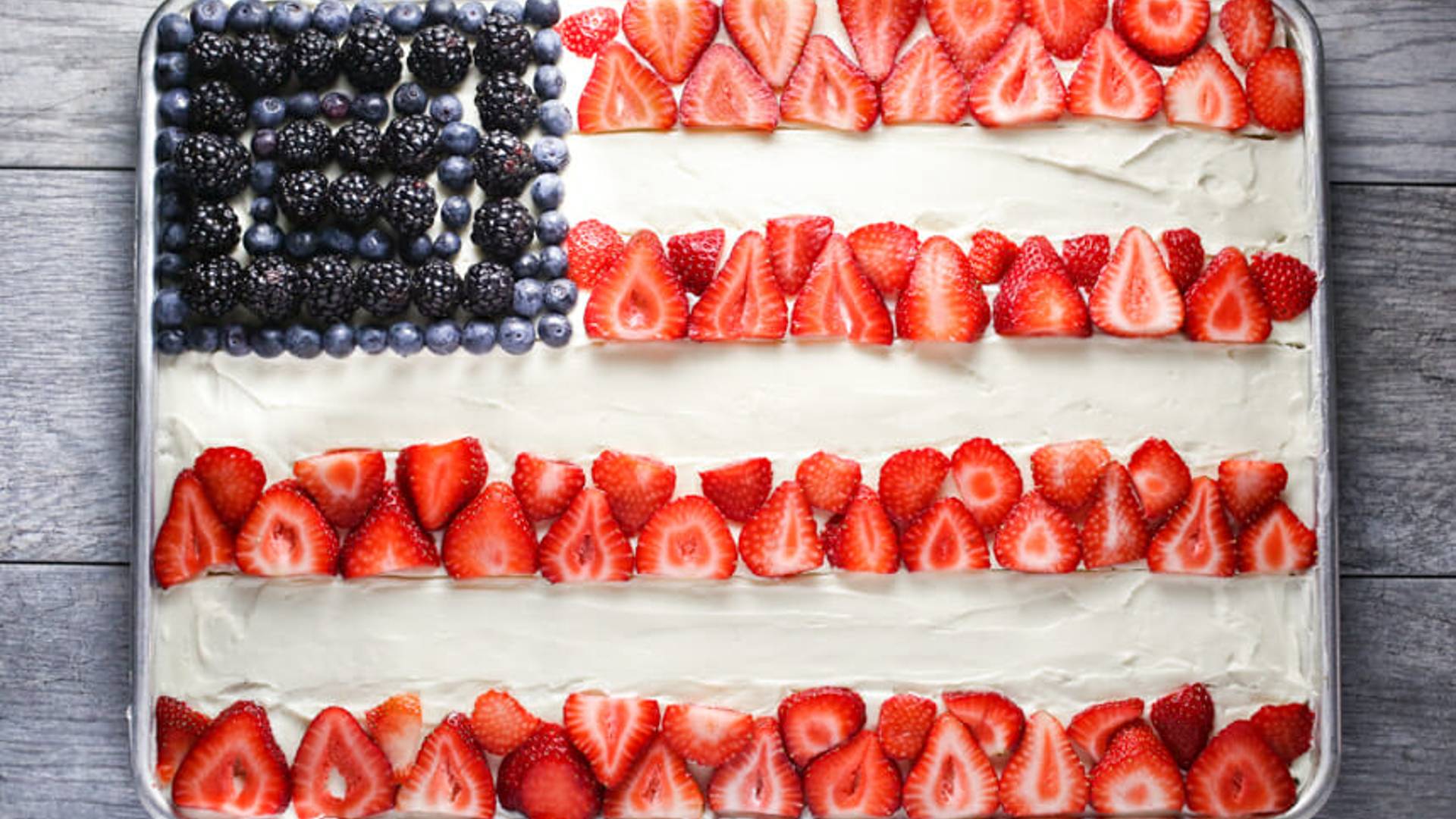 a sheet cake with an american flag made out of berries
