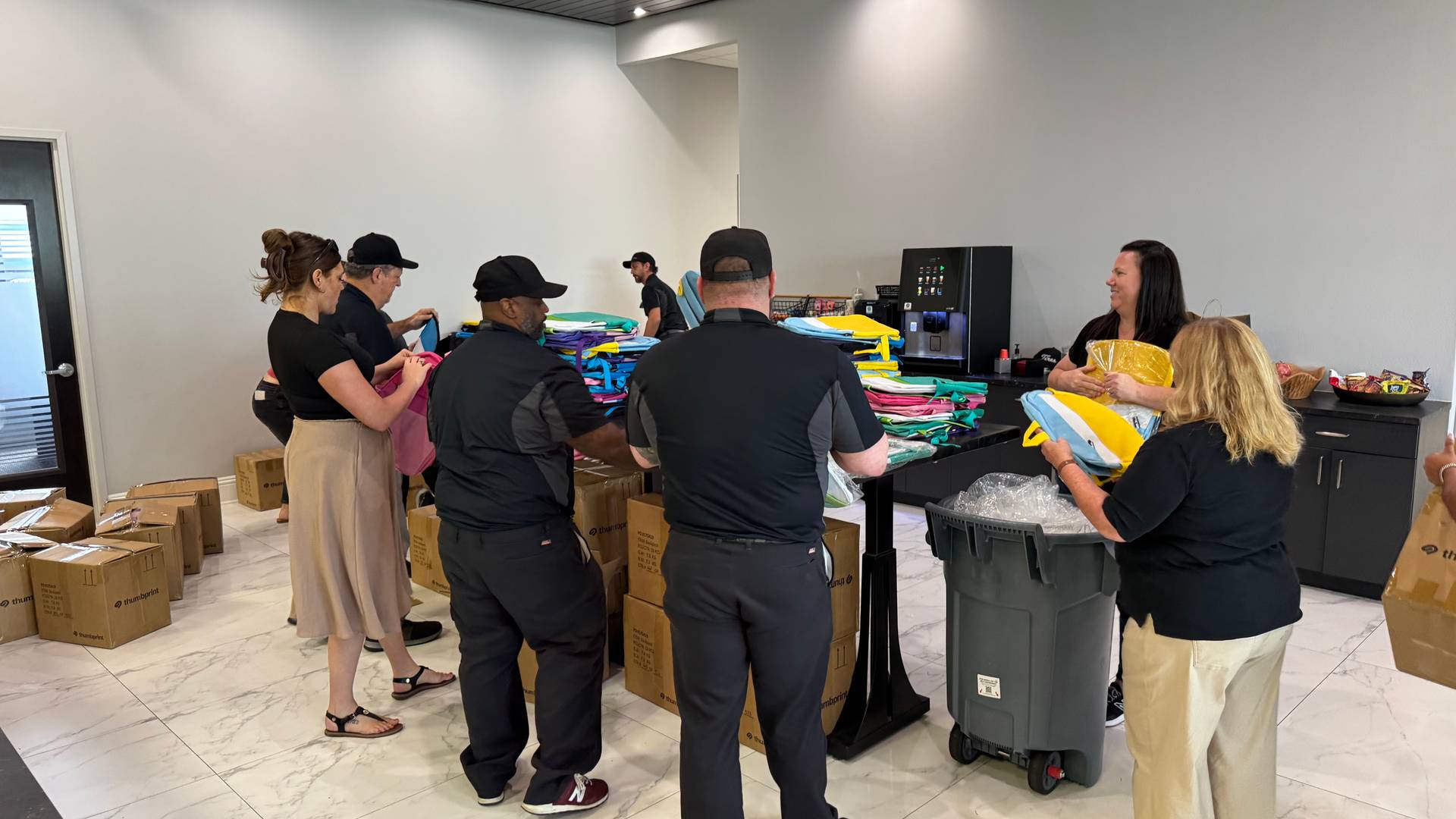 team members stuffing backpacks with supplies