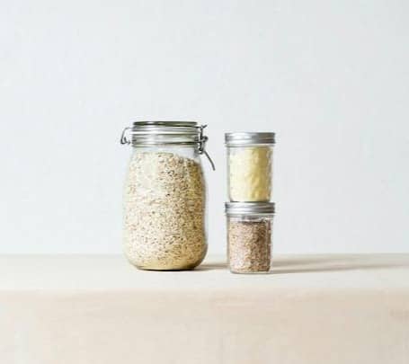 2 clear glass condiment shakers on white table
