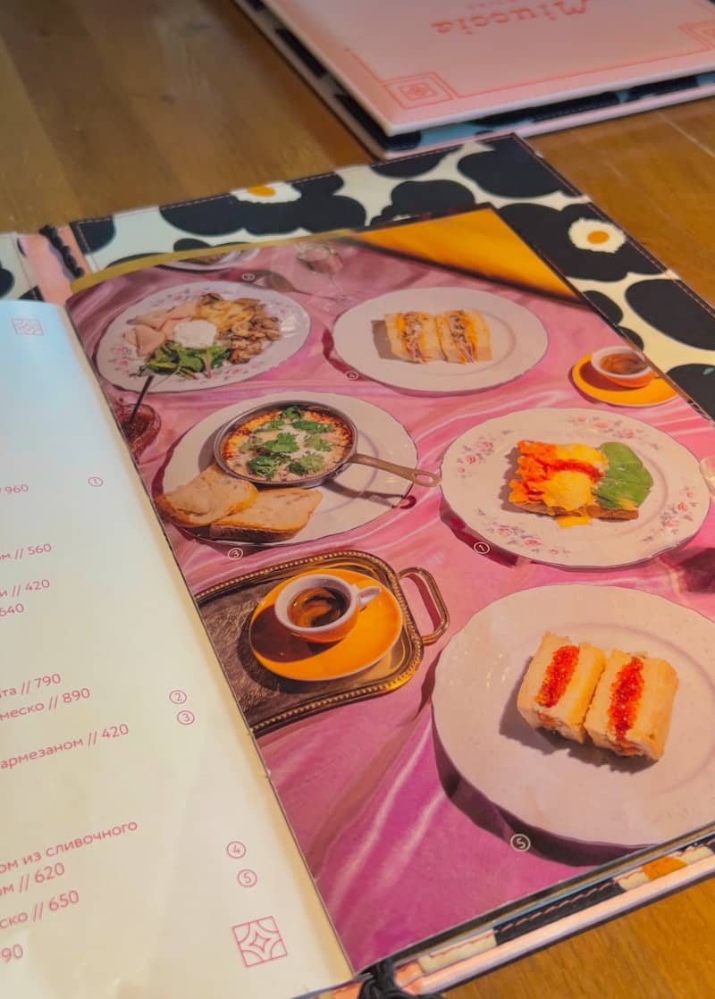 A table topped with plates of food and a menu