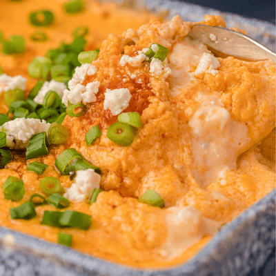 Frank's RedHot buffalo chicken dip topped with blue cheese crumbles and green onion topss