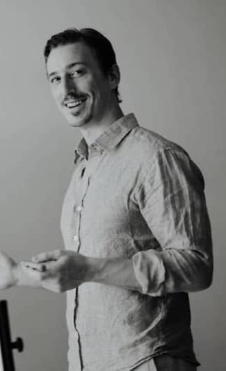 Man presenting by a whiteboard in a studio.