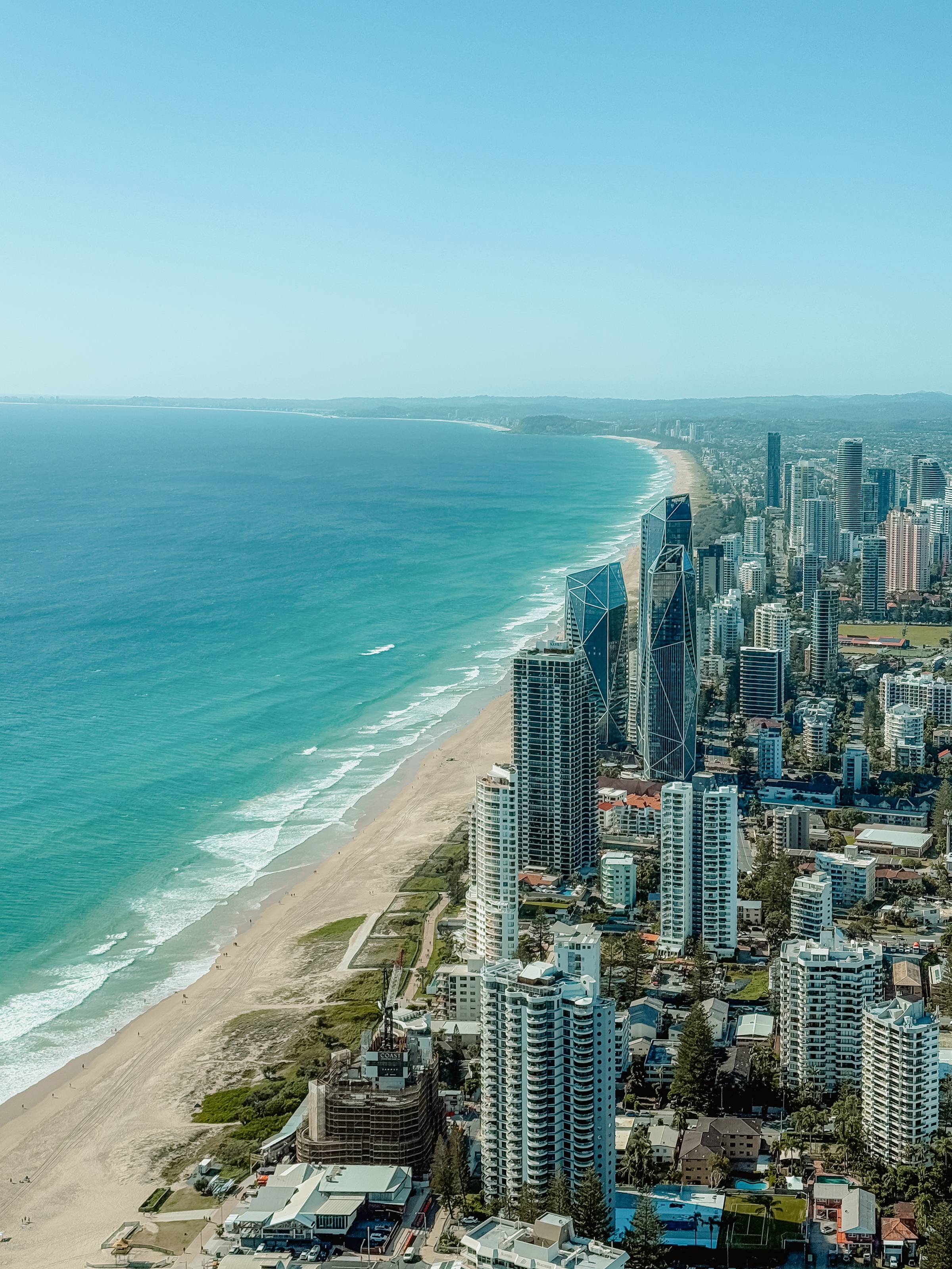 A city of skyscrapers lined along an expansive beach and turquoise ocean.