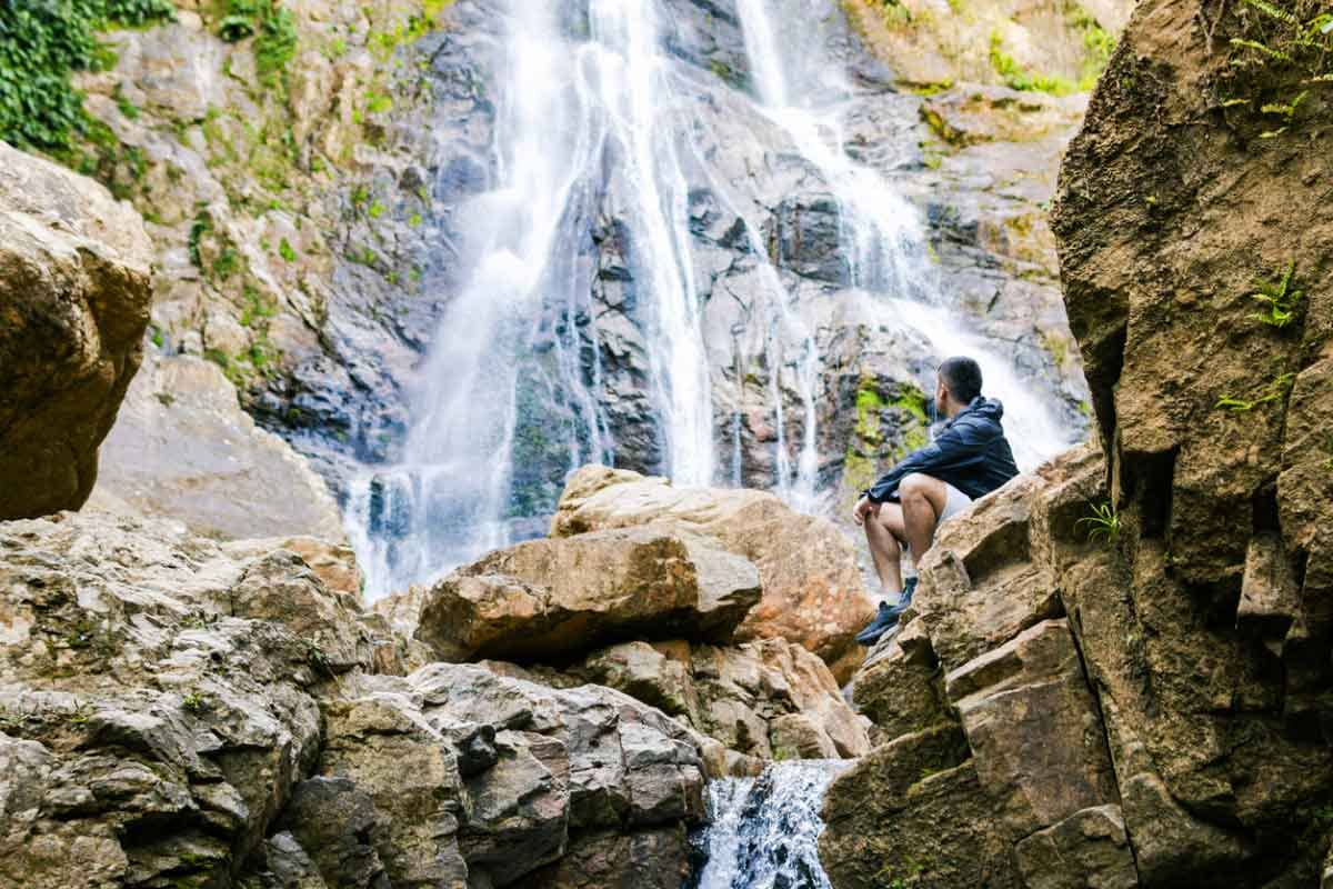 A man enjoys the scenic beauty of a waterfall in Colombia