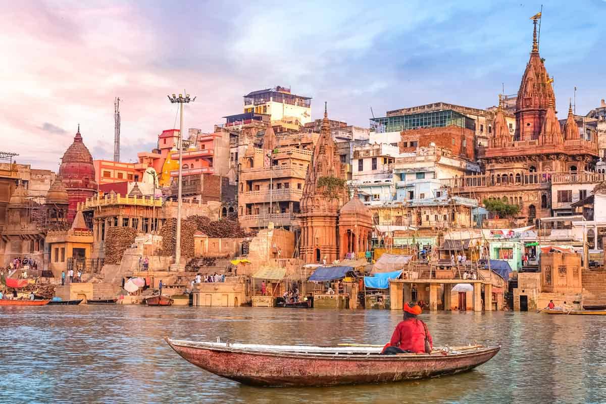 An Indian sadhu sitting a boat on the river Ganges at sunset.