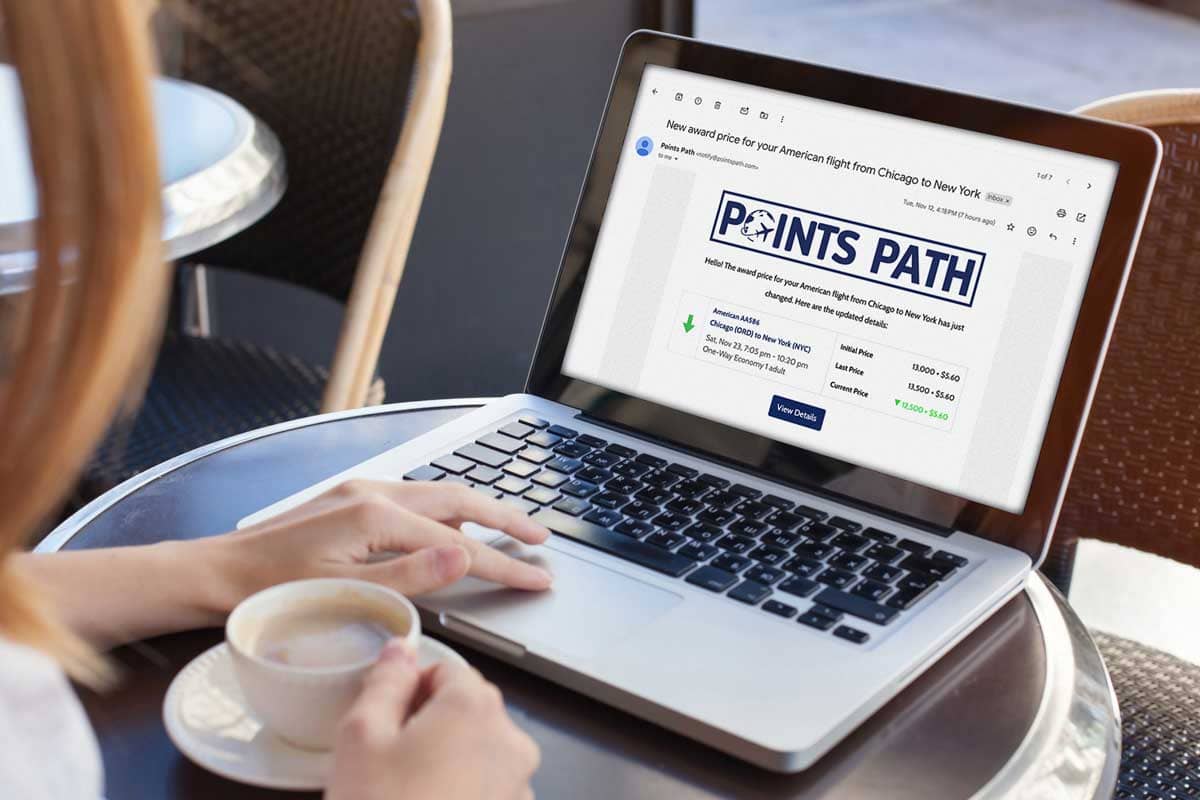 A woman reads a Points Path price alert email on her laptop.