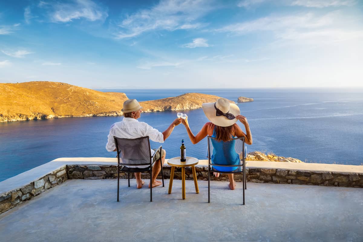 Couple clinking glasses on a terrace overlooking the sea