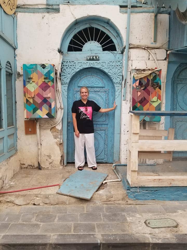 Headshot of the author Holly Johnson standing in an arched doorway.