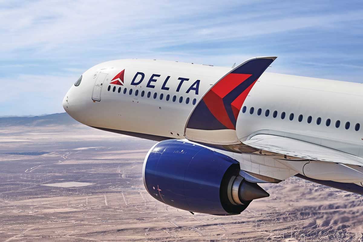 A Delta flight flying above the ground as seen from the wing.