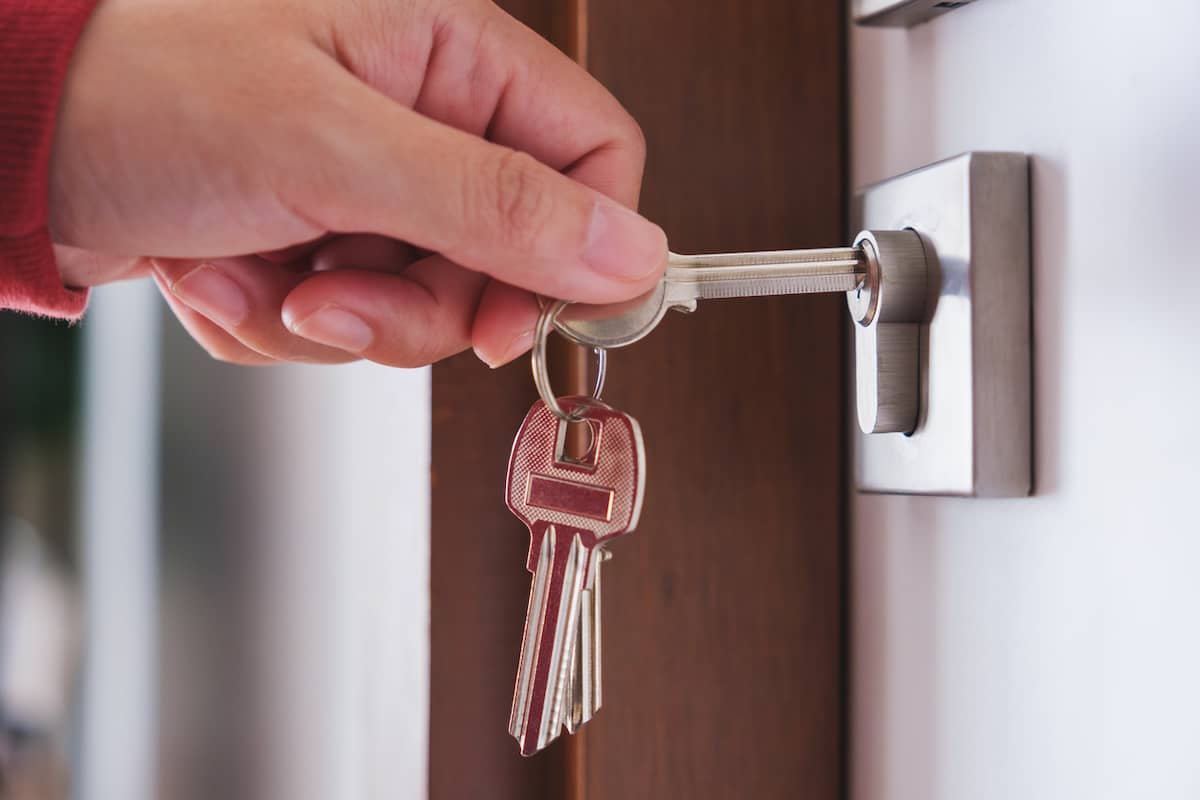 Hand turning a key in an apartment door lock