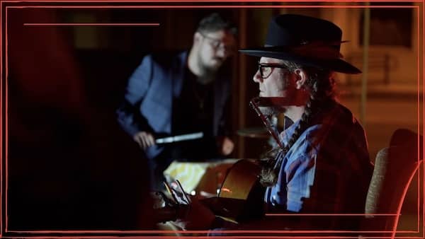 Ezra Vancil playing acoustic guitar on stage