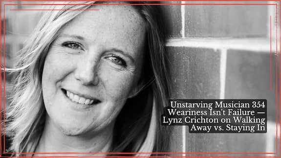 Black and white headshot of Lynz Crichton, smiling with head tilted next to a brick wall