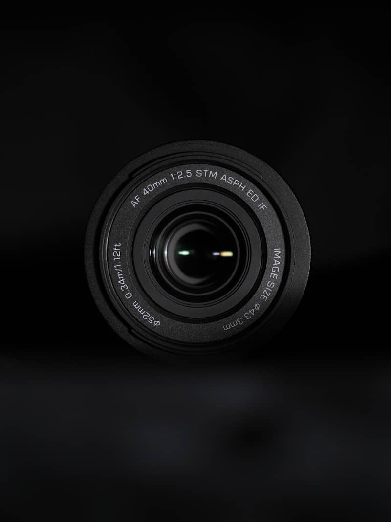 A camera lens is centered against a dark background.