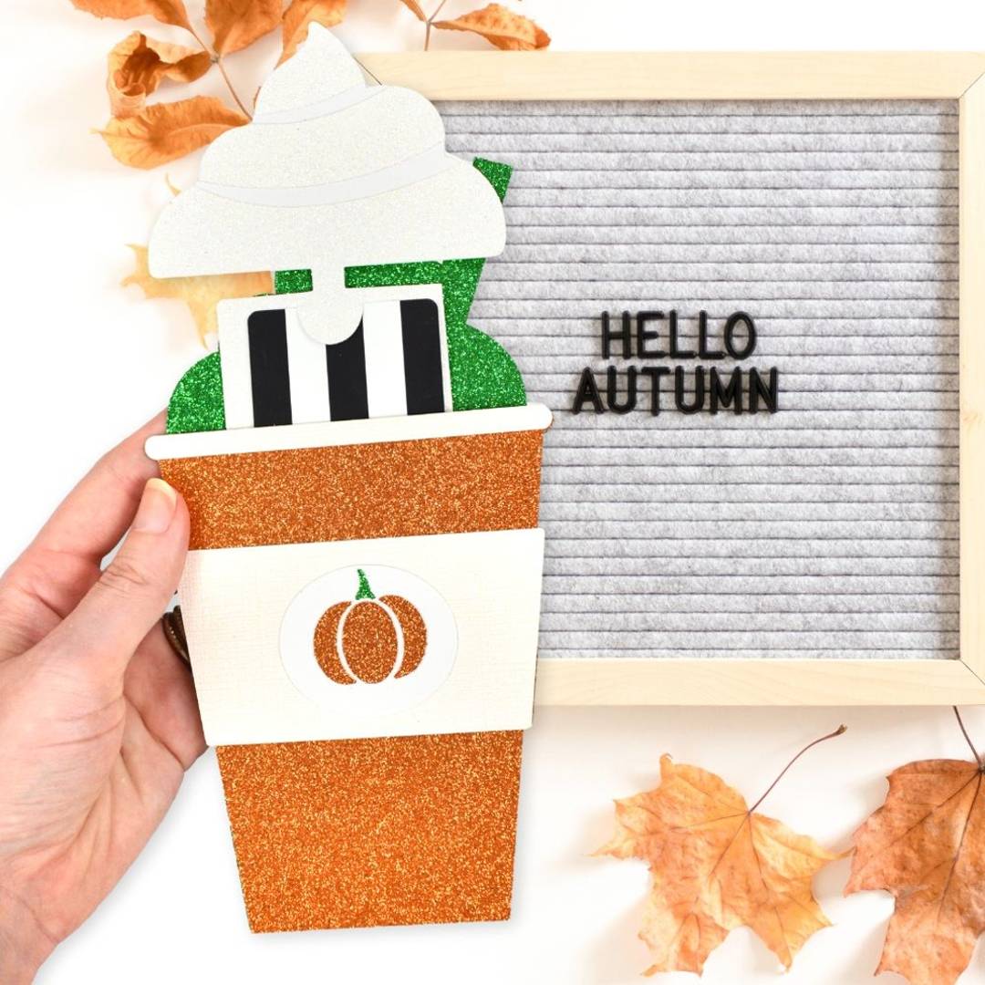 a hand holding a pumpkin spice latte cup gift card holder